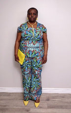 Plus size woman wearing a colorful patterned outfit with a yellow clutch against a plain background