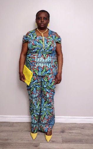 Plus size woman wearing a colorful patterned outfit with a yellow clutch against a plain background