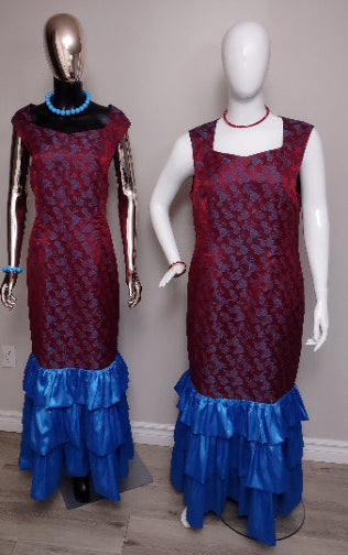 Two mannequins wearing red and blue patterned dresses with ruffled blue skirts on a plain background.