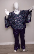 Mannequin wearing a floral blouse and purple pants against a plain background