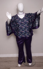 Mannequin wearing a floral blouse and purple pants against a plain background