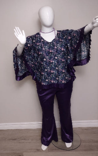 Mannequin wearing a floral blouse and purple pants against a plain background