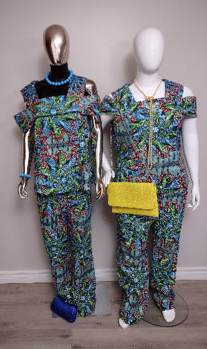 Two mannequins wearing matching colorful outfits with yellow clutch on a plain background